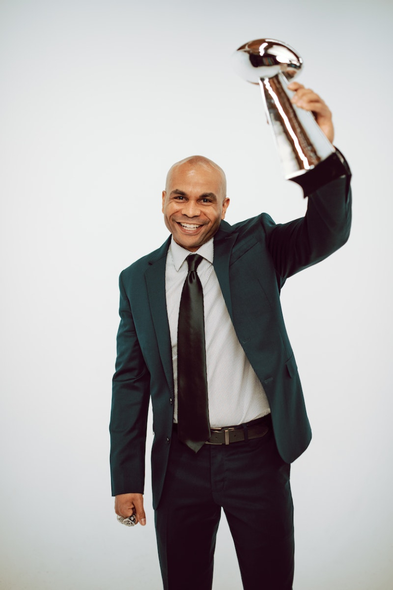 A Man in Formal Wear Holding a Trophy