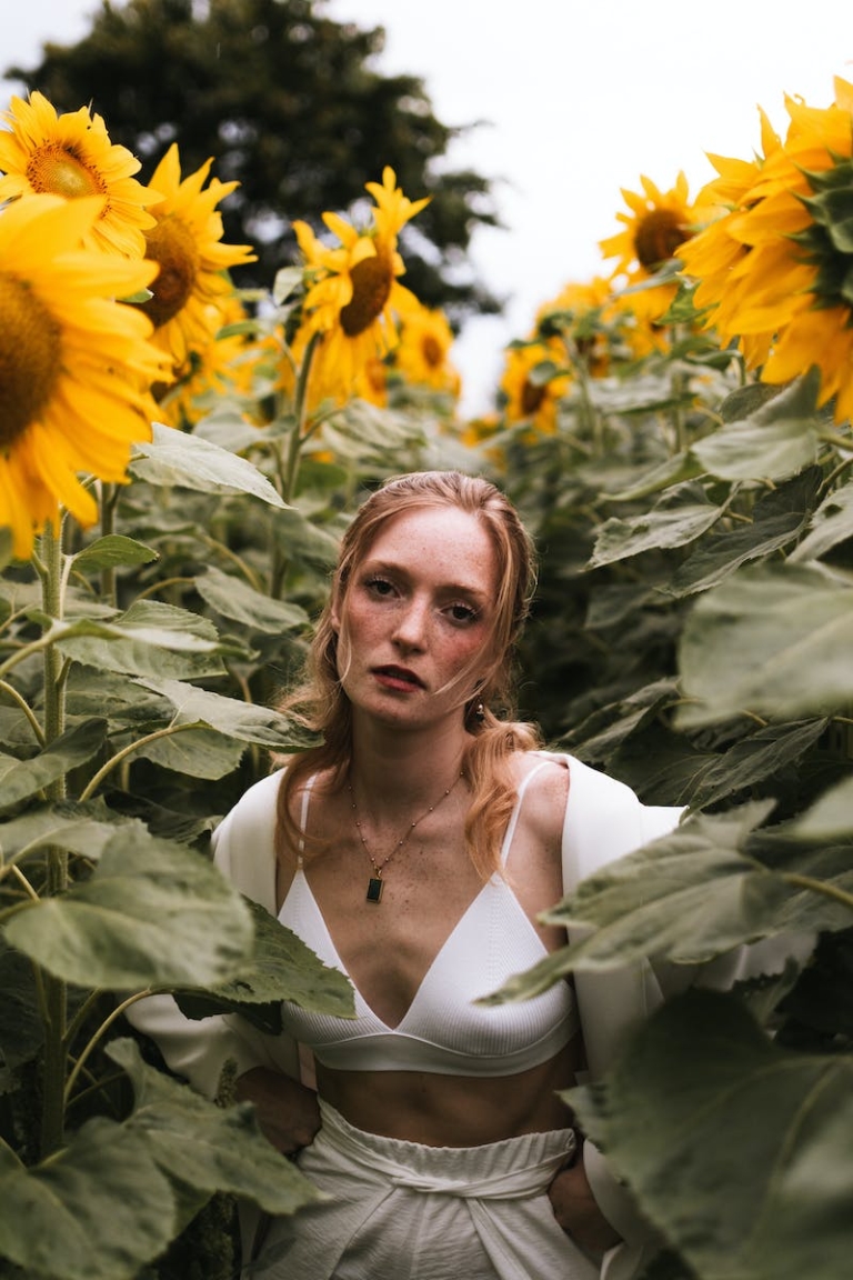 A woman in a white top and sunflowers