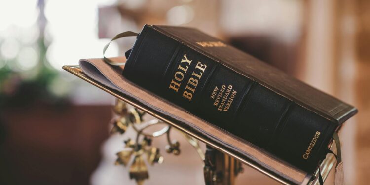 Holy Bible open on a stand inside a church, symbolizing faith and spirituality.