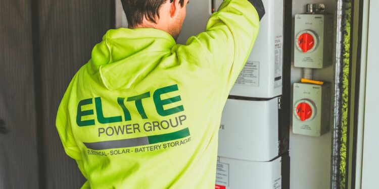 Technician installing a solar inverter and battery system in New South Wales.