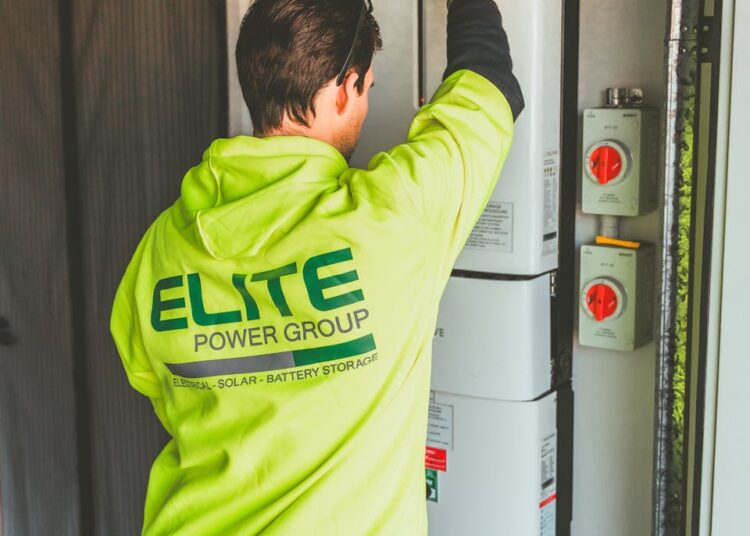 Technician installing a solar inverter and battery system in New South Wales.