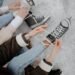 Women tying shoelaces on ice skates on a snowy winter day. Perfect for lifestyle and winter sports themes.