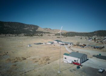 Aerial view capturing a wind turbine in a rural landscape, showcasing sustainable energy.