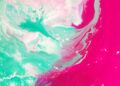 Dynamic abstract painting with vibrant pink and teal swirls creating a modern artistic expression.