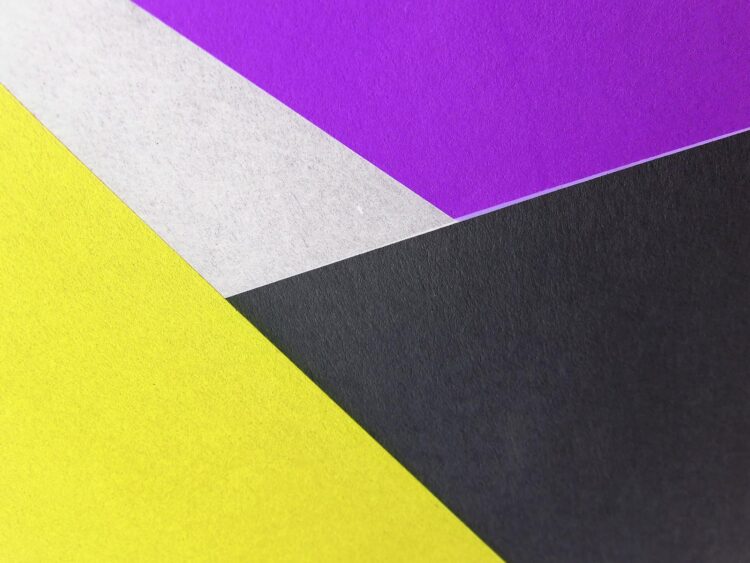 Vibrant geometric composition with yellow, purple, black, and white paper textures.