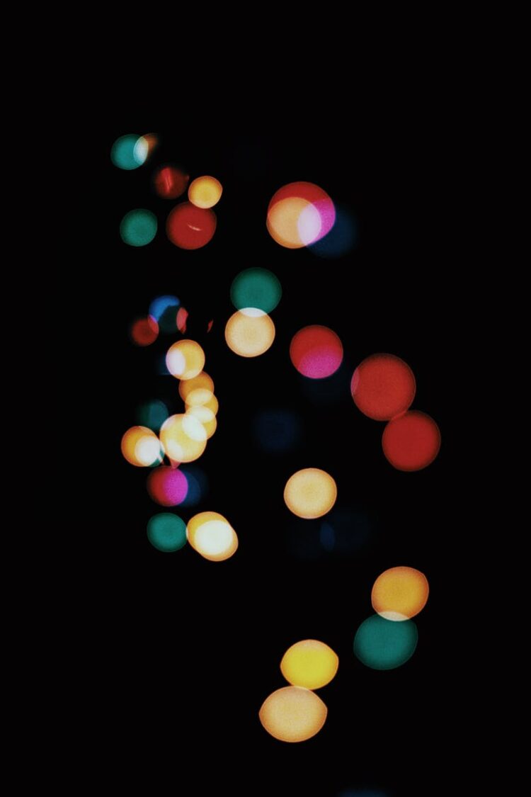 Abstract bokeh lights creating a vibrant, colorful pattern against a dark background.