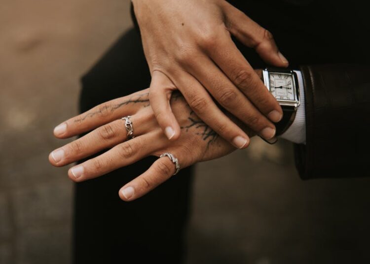 Close-up portrait of a fashionable man with tattoos and rings in Lille, France.