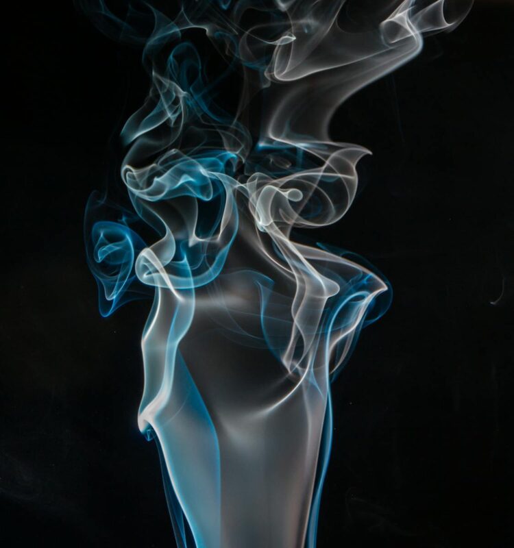 Captivating abstract visual of blue and white smoke swirls against a dark background, perfect for creative projects.