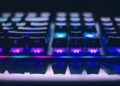 A detailed close-up of illuminated mechanical keyboard keys with focus on blue and purple lights.