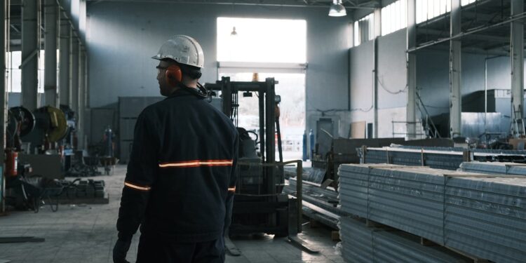A worker in protective gear supervises operations in a modern Ankara factory.