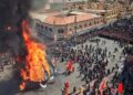 group of people standing surrounded on burning tipi tent during daytime