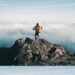 Trail runner reaching a mountain summit above the clouds, a comeback story