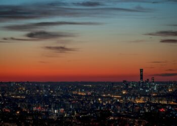 A view of a city at night from the top of a hill