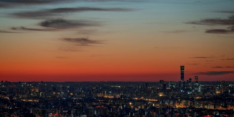 A view of a city at night from the top of a hill