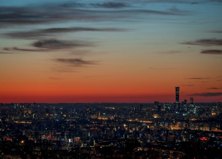A view of a city at night from the top of a hill