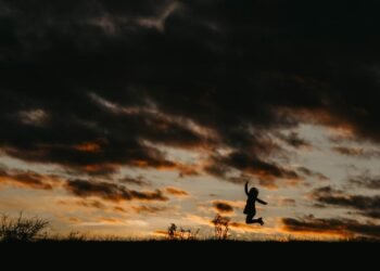 silhouette of jumping person during golden hour