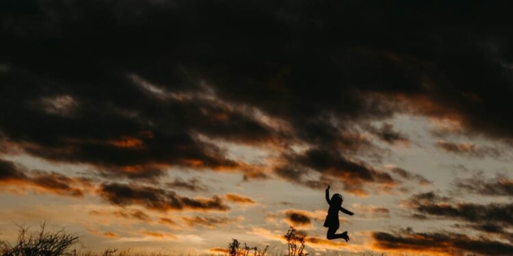 silhouette of jumping person during golden hour