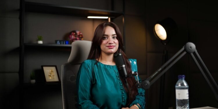 Smiling woman newscaster in a television news studio, placeholder for the Good News host