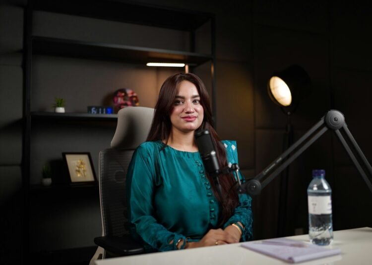 Smiling woman newscaster in a television news studio, placeholder for the Good News host