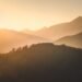 Sunrise casting warm light over a misty mountain landscape