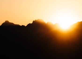 Sun rising over mountains with golden light