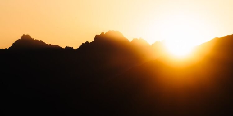 Sun rising over mountains with golden light