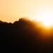 Sun rising over mountains with golden light