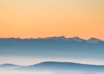 Misty mountains at sunrise in soft pastel tones