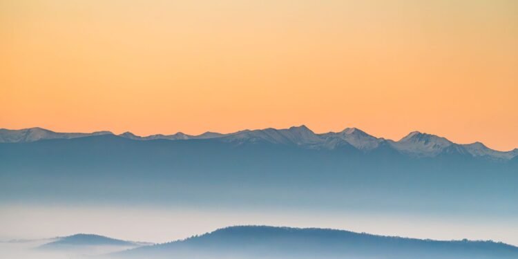 Misty mountains at sunrise in soft pastel tones