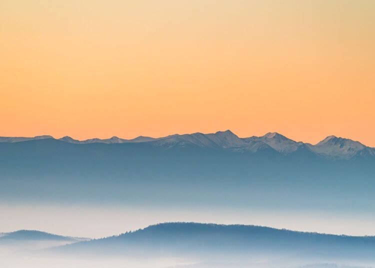 Misty mountains at sunrise in soft pastel tones