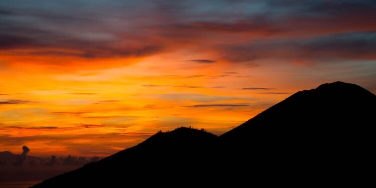 Vivid sunset behind a dark mountain silhouette