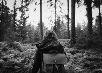 Hiker with a backpack walking through a quiet forest