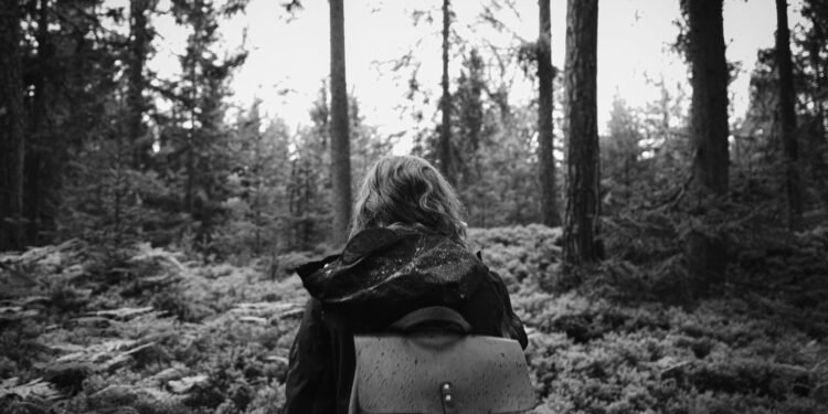 Hiker with a backpack walking through a quiet forest