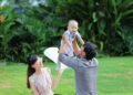A father lifting his baby boy in a garden, Positive Phil