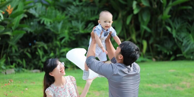 A father lifting his baby boy in a garden, Positive Phil