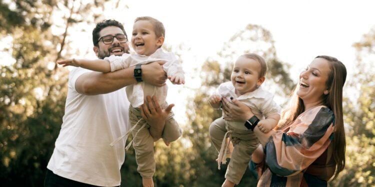 A happy family with two children playing outdoors in summer, Positive Phil