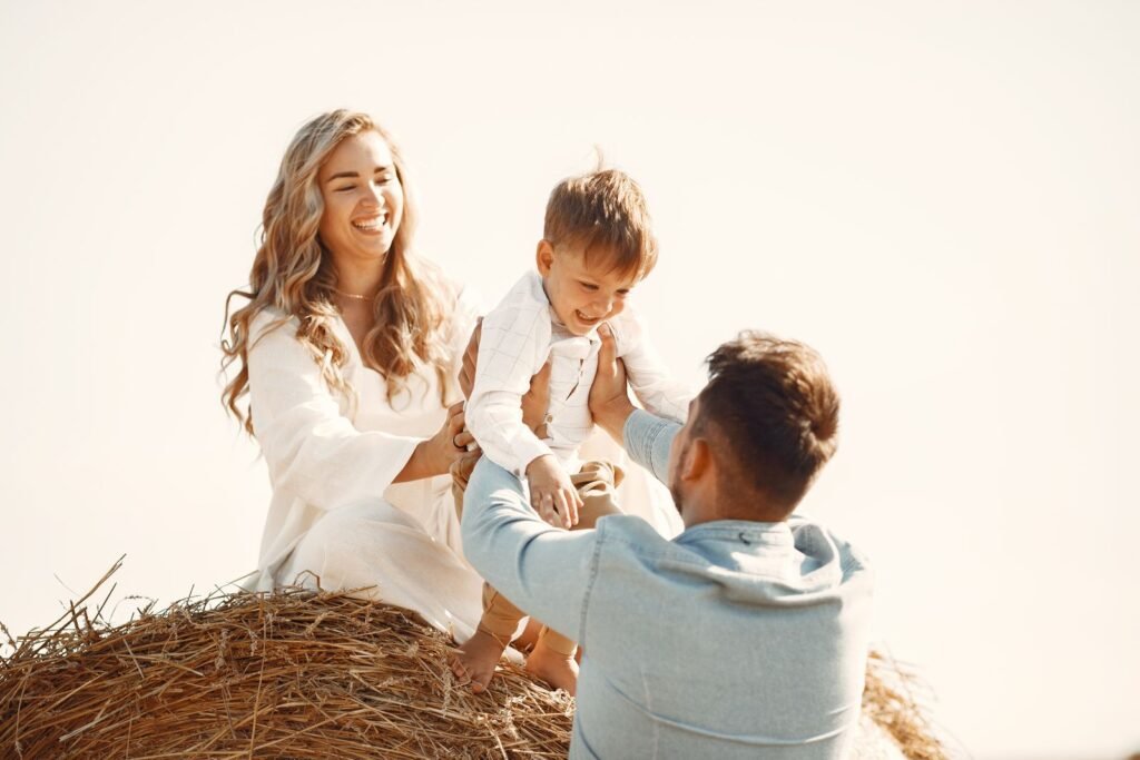 A family laughing together on a hay bale, Positive Phil