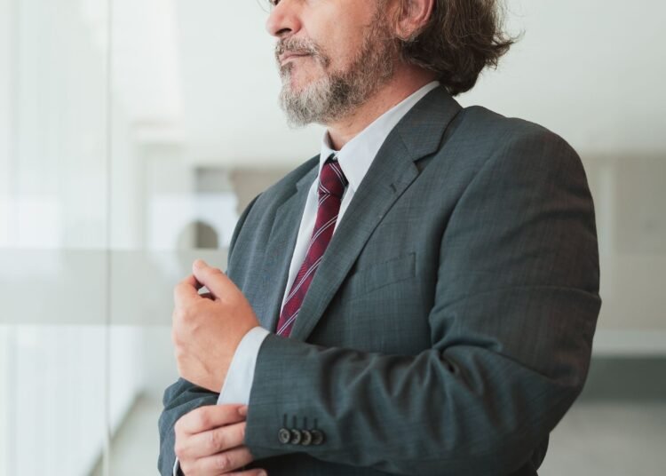 A businessman adjusting his cufflinks, Positive Phil