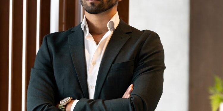 A confident businessman standing in a bright office, Positive Phil