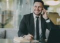 A smiling businessman on a phone call, Positive Phil