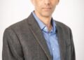 A man in formal attire against a white background, Positive Phil