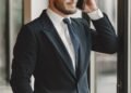 A businessman in a suit on the phone by a window, Positive Phil