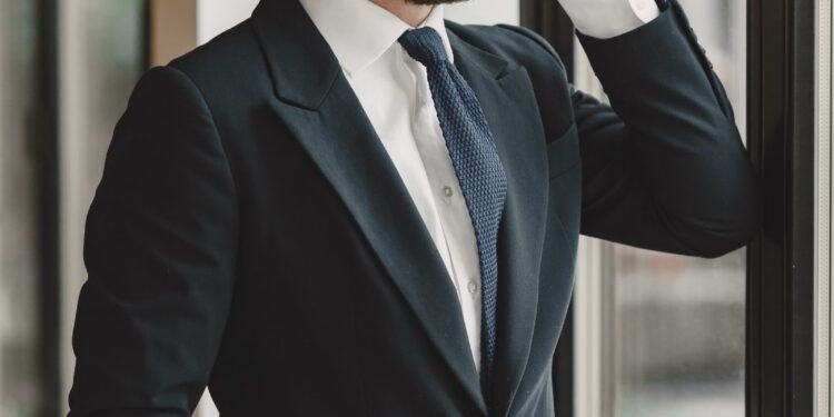 A businessman in a suit on the phone by a window, Positive Phil
