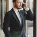 A businessman in a suit on the phone by a window, Positive Phil