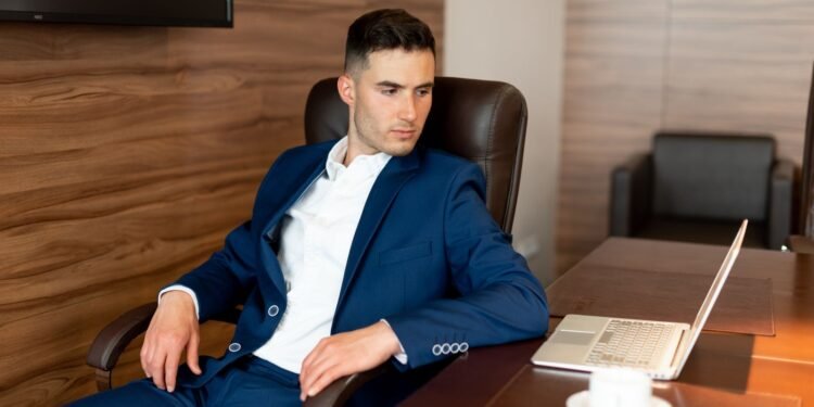 A businessman in a blue suit at his desk, Positive Phil