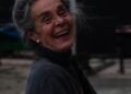 An older woman with gray hair smiling outdoors, Positive Phil