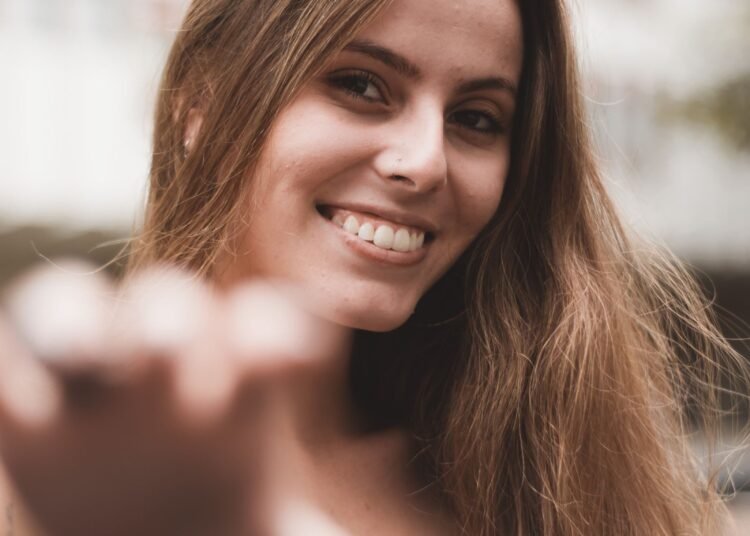 A young woman smiling on a sunny day outdoors, Positive Phil