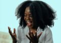A woman with curly hair laughing, Positive Phil