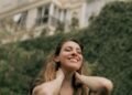 A smiling woman enjoying a calm moment outdoors, Positive Phil