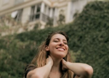 A smiling woman enjoying a calm moment outdoors, Positive Phil